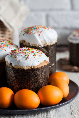 Close-up of decorated Easter cakes and yellow colored eggs on a plate on the table.の写真素材
