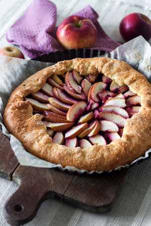 Sweet galette with apples and elder berries on wooden board.の写真素材