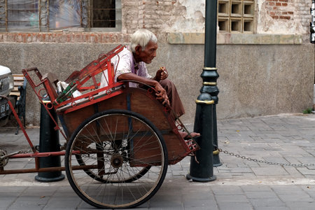 Kota Lama, Semarang / Indonesia - July 6 2020 :  Becak driver is waiting for passenger at "Kota Lama" Semarang, Indonesia.  Becak, pedicab, rickshaw, is traditional vehicle from Indonesia.のeditorial素材