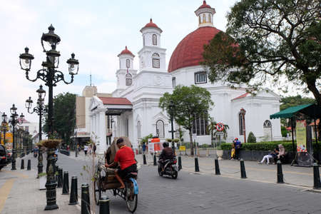 Kota Lama, Semarang / Indonesia - July 6 2020 :  Becak ride along Blendug Church or Immanuael Church "Kota Lama" Semarang, Indonesia. Becak, pedicab, rickshaw, is traditional vehicle from Indonesia.のeditorial素材