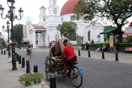 Kota Lama, Semarang / Indonesia - July 6 2020 :  Becak ride along Blendug Church or Immanuael Church...