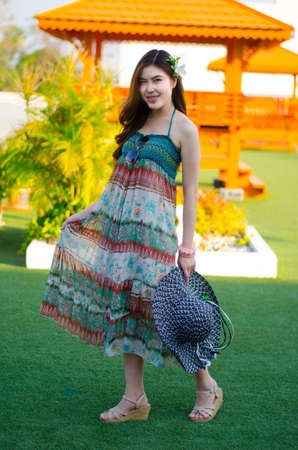 Young cute summer girl on green grass outside relaxing smilingの写真素材