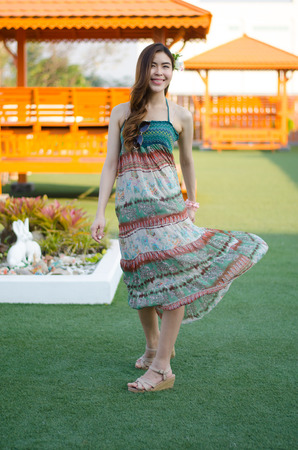 Young cute summer girl on green grass outside relaxing smilingの写真素材