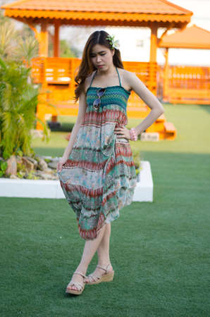 Young cute summer girl on green grass outside relaxing smilingの写真素材