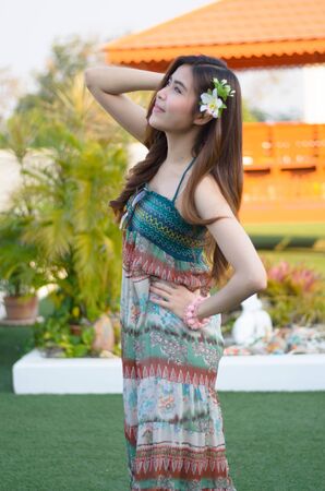 Young cute summer girl on green grass outside relaxing smilingの写真素材