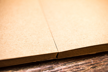 Old beige grained paper for painting on old grungy dark brown wooden table background close up. Soft focusの写真素材