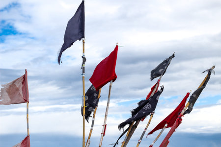 Colorful red blue and black flags on a boat or ship against blue sky with clouds at Baltic Sea in Polandの写真素材