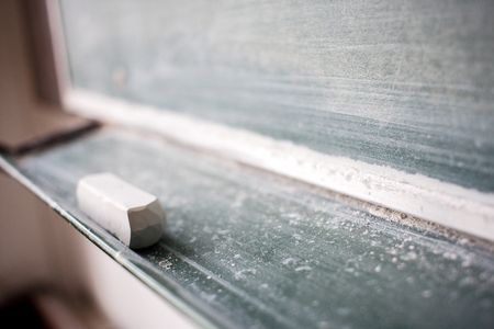 Piece of chalk under blackboard. Soft, shallow focusの写真素材