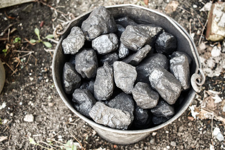 Black coal, carbon in old grungy metallic bucket