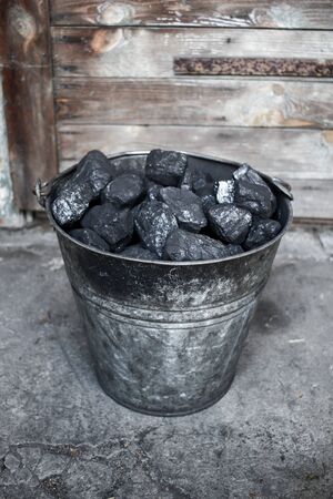 Black coal, carbon in old grungy metallic bucketの写真素材