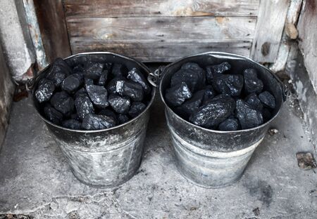 Black coal, carbon in old grungy metallic bucketの写真素材