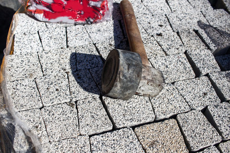 Close up of a working tool for setting a brick pavement or street