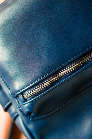 Close up of blue leather women backpack, rucksack detail on wooden backgroundの写真素材