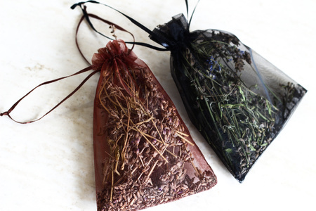 Dried scented herbs in red decorative bags: brown and black. Fresh smell of meadow in your houseの写真素材