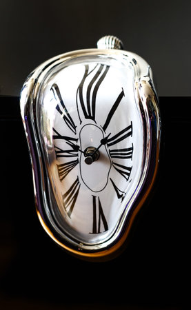 Distorted photograph of a surreal watch over black background. Detailの写真素材