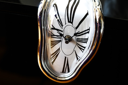Distorted photograph of a surreal watch over black background. Detailの写真素材