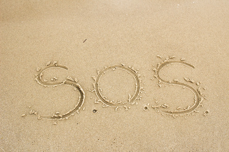 Nice, pleasant and simple sunny summer composition on holidays. Happy relaxing vacations. Text words on wet sand on beach, concept of SOS helpの写真素材
