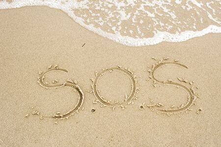 Nice, pleasant and simple sunny summer composition on holidays. Happy relaxing vacations. Text words on wet sand on beach, concept of SOS help. On uninhabitated islandの写真素材