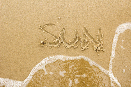 Nice, pleasant and simple sunny summer composition on holidays. Happy relaxing vacations. Text words on wet sand on beach, concept of sunの写真素材