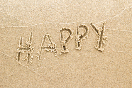 Nice, pleasant and simple sunny summer composition on holidays. Happy relaxing vacations. Text words on wet sand on beach, concept of being happyの写真素材