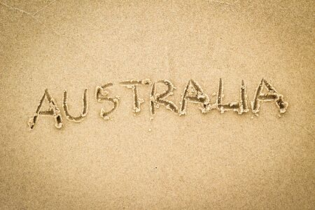 Nice, pleasant and simple sunny summer composition on holidays. Happy relaxing vacations. Text words on wet sand on beach, concept of Australiaの写真素材