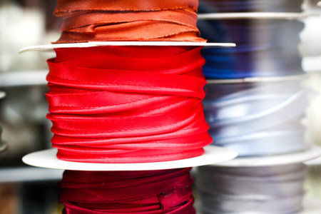 Various choice of different colorful decorative ribbons at traditional notions store. Display macro close up with window reflections. Poland, Torunの写真素材
