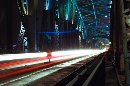 Detail of a bridge with road for cars at night. Many lights over dark sky.の写真素材