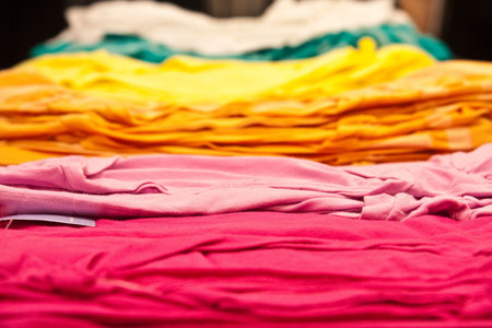 A stack of colorful t-shirts on a table.の写真素材