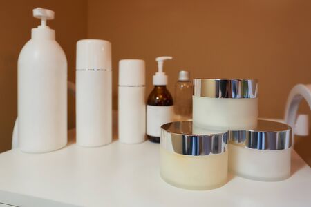 All kinds of skincare products on a white trolley cart in a cosmetology office.の写真素材