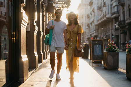 A girl in a hat and a yellow dress with a plunging neckline and her boyfriend with a beard and...