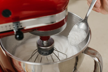 A close photo of the falling starch from the spoon to stainless steel soup bowl with the mixed egg...