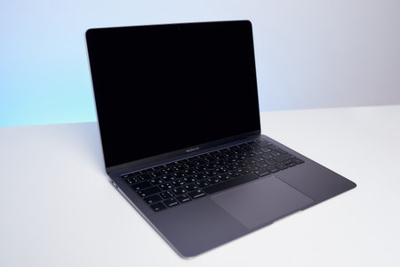 Minsk, Belarus - December 04 2020: an opened brand new Space Gray MacBook Air 2019 on the white table. The laptop designed by Apple in California, assembled in Chinaのeditorial素材