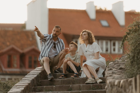 A family is relaxing on the stairs between roofs in an old European townの写真素材