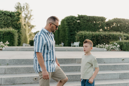 Father and son are talking in the garden of a European town. Happy familyの写真素材