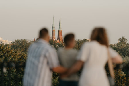 Father, mother and son are holding hands on the green cobbled streetの写真素材