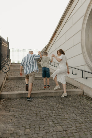 A family is climbing the stairs of the palace in an old European town.の写真素材