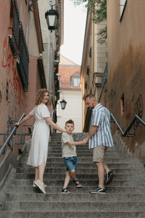 Family is climbing stairs in an old European town.の写真素材