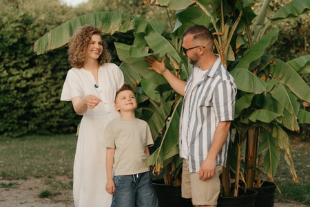 Father, mother, and son are having fun with palm trees in the background.の写真素材