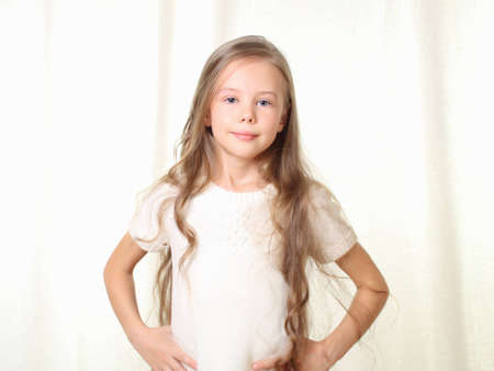 Portrait of little blond girl with hands on hipsの写真素材