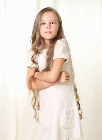 Little blond girl posing with crossed hands on her breastの写真素材