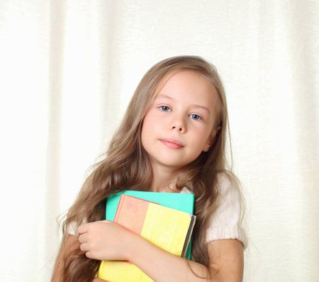 Little blond girl holding different books and smiling