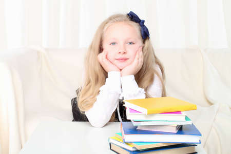 Little girl reading a book sitting on sofaの写真素材