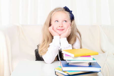 Little girl reading a book sitting on sofaの写真素材