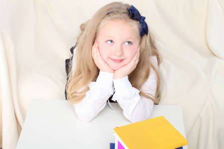 Little girl reading a book sitting on sofaの写真素材