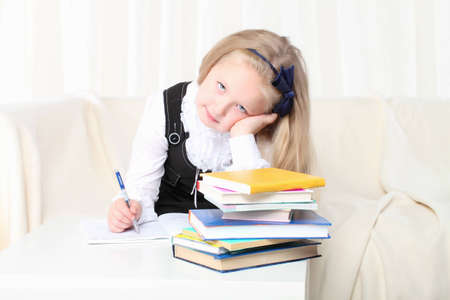 Little girl reading a book sitting on sofaの写真素材