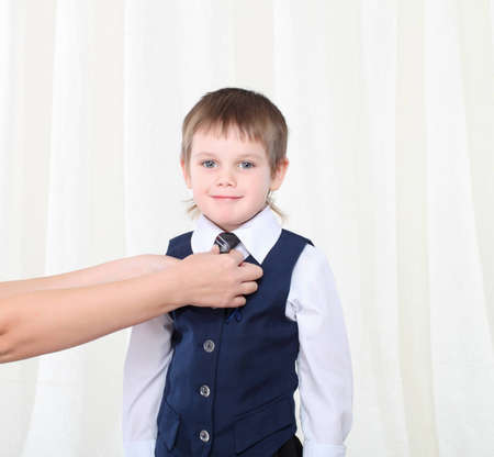 Mother's hands correcting her son's tieの写真素材