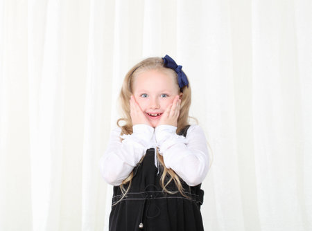 Little girl amased holding palms near cheeks
