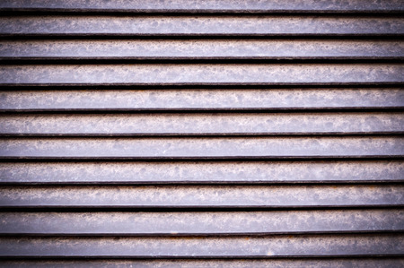 horizontal stripes of dusty metal jalousie exterior with vignette. background, texture.の写真素材