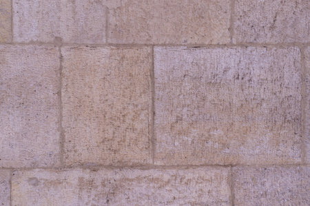 beige weathered granite stone tiled wall background. texture.