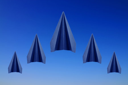 origami five blue paper planes on blue sky background